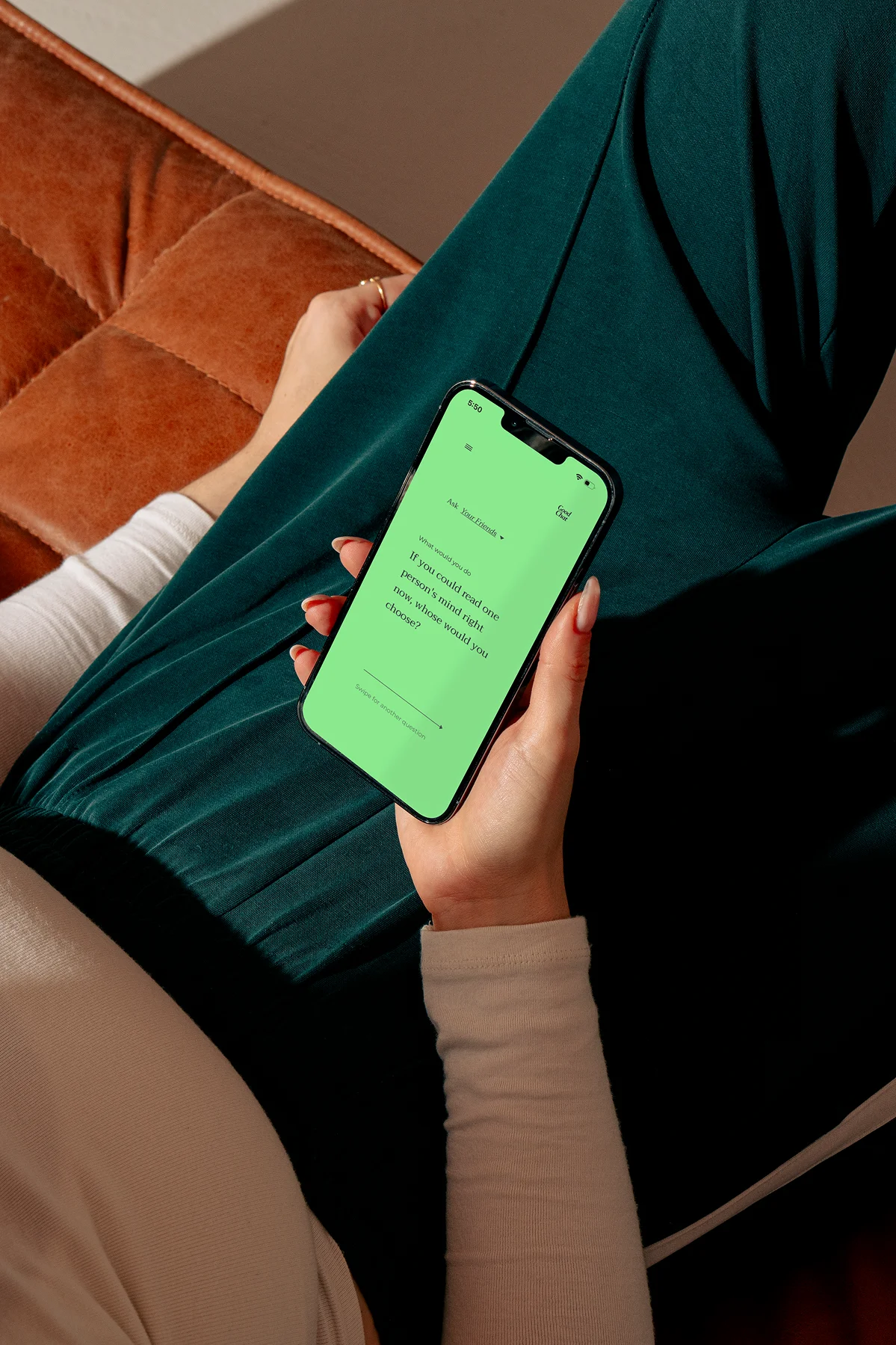 Holding a phone with the Good Chat app on green screen