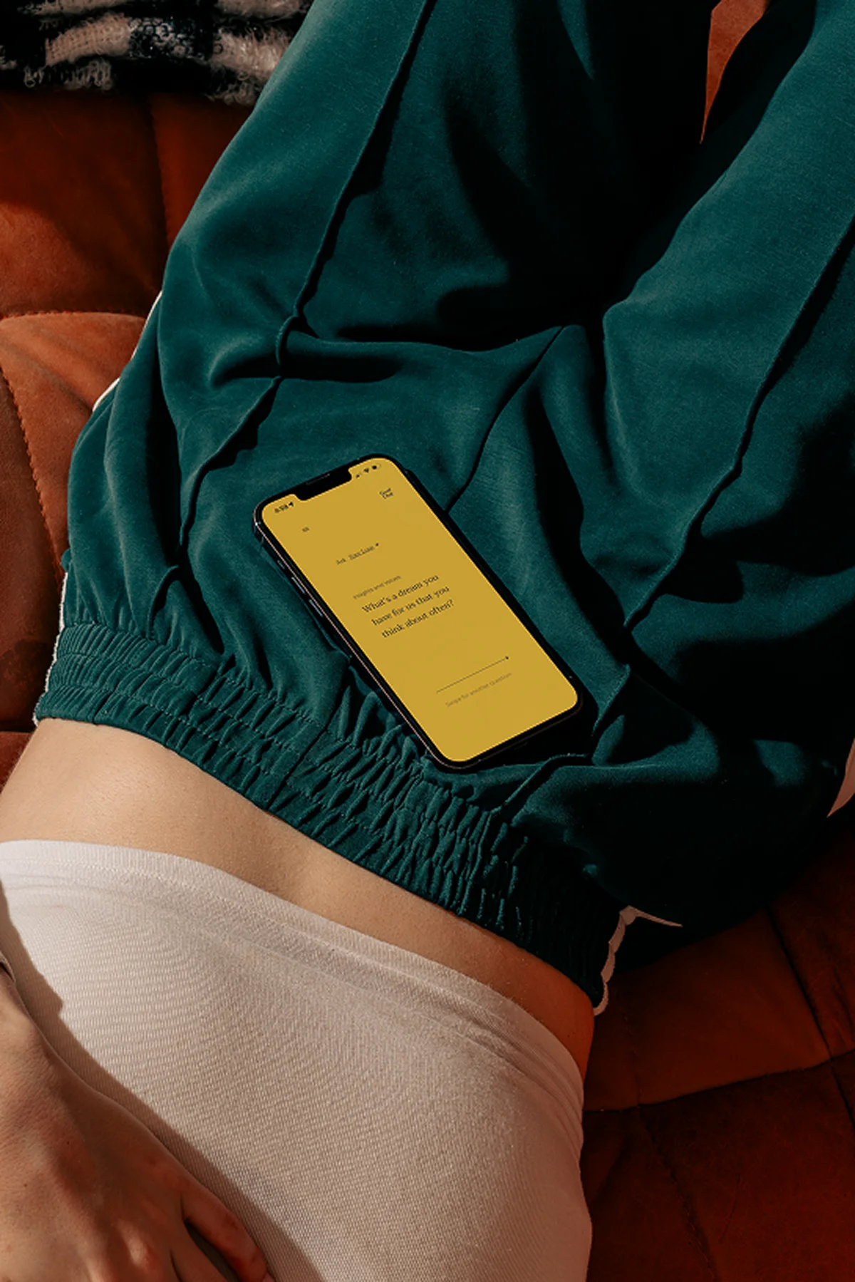 Phone resting in lap showing Good Chat app on yellow screen